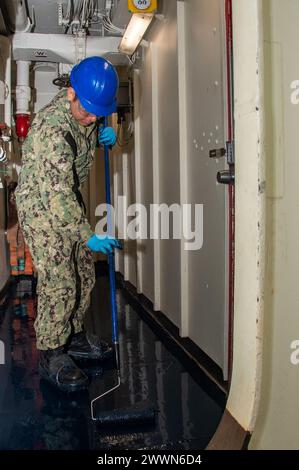 YOKOSUKA, Japan (28. Februar 2024) Aviation Boatswain’s Mate (Launch and Recovery Equipment) Airman Christian Lazaro, aus Chicago, legt Bodenharz mit einer Walze in einem Durchgang an Bord des einzigen vorwärtsgerichteten Flugzeugträgers der US Navy, USS Ronald Reagan (CVN 76), während im Hafen Commander, Fleet Activities Yokosuka, 28. Februar. Ronald Reagan, das Flaggschiff der Carrier Strike Group 5, stellt eine kampfbereite Truppe zur Verfügung, die die Vereinigten Staaten schützt und verteidigt und Allianzen, Partnerschaften und kollektive maritime Interessen in der indopazifischen Region unterstützt. Marineblau Stockfoto