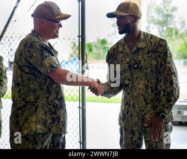 APRA HARBOR, Guam (7. Februar 2024) – Elektrician’s Mate 3rd Class Maurice Lewis, der dem Emory S. Land-Klasse-U-Boot-Tender USS Emory S. Land (AS 39) zugewiesen wurde, erhält eine Challenge Coin von der ADM. Michael Van Poots, Deputy Commander Submarine Force Atlantic/Deputy Commander Submarine Force Pacific, 7. Februar 2024. Frank Cable repariert, rüstet U-Boote und Überwasserschiffe in der indopazifischen Region wieder auf. Marineblau Stockfoto