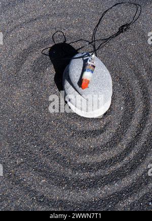Heilungskristalle-Pendel auf schwarzem Sandgrund Stockfoto