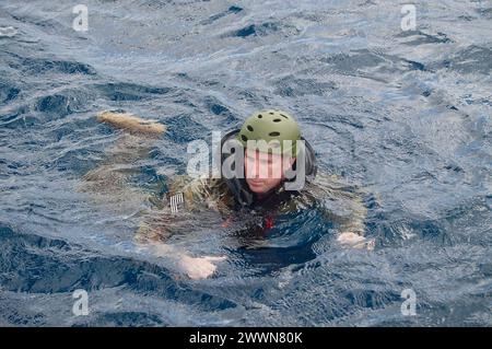 Ein U.S. Army Scout schwimmt, nachdem er am 1. Februar 2024 von einem U.S. Navy Helicopter Sea Combat Squadron 25 MH-60S KnightHawk Hubschrauber über APRA Harbor in Guam eingesetzt hat. In einer Demonstration der dienststellenübergreifenden Zusammenarbeit und des Fachwissens unterstützte die Crew des 45-Fuß-Response Boat-Medium der US-Küstenwache APRA Harbor ein kompliziertes Cast- und Recovery-Training. Dieses wichtige Training beinhaltete die Zusammenarbeit mit den Pfadfindern der 3rd Squadron, den 4th U.S. Kavallerry Raiders des 3rd Infantry Brigade Combat Teams (IBCT), der 25th Infantry Division und dem U.S. Navy Helicopter Sea Combat Squ Stockfoto