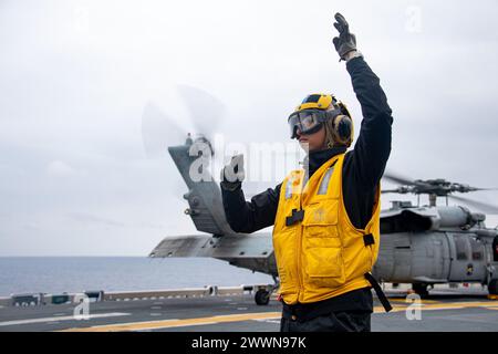 PACIFIC OCEAN (16. Februar 2024) Aviation Boatswain’s Mate (Handling) Airman Apprentice David Bollas aus Chicago, der dem vorwärtsgerichteten amphibischen Angriffsträger USS America (LHA 6) zugeteilt wurde, signalisiert einem Sailor, das Flugdeck zu überqueren, während er Flugoperationen im Pazifischen Ozean durchführt. America, Leitschiff der America Amphibious Ready Group, ist im Einsatzgebiet der 7. US-Flotte im Einsatz. Die 7. US-Flotte ist die größte nach vorne gerichtete nummerierte Flotte der US Navy und interagiert routinemäßig mit Verbündeten und Partnern, um ein freies und offenes Indo-Pacif zu erhalten Stockfoto