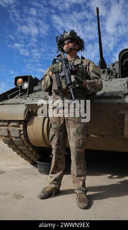 Thomas Knowles, ein Kavallerie-Pfadfinder der 5. Squadron, 7. Kavallerie-Regiment, 3. Infanterie-Division, steht am 15. Februar 2024 vor einem Bradley-Kampffahrzeug in Fort Stewart, Georgia. Schulungen wie Schießtische helfen den Einheiten, ihre Einsatzbereitschaft zu wahren, indem sie Soldaten auf mehrere Szenarien vorbereiten und Probleme vorbereiten, die in einer Feldumgebung auftreten können. Armee Stockfoto