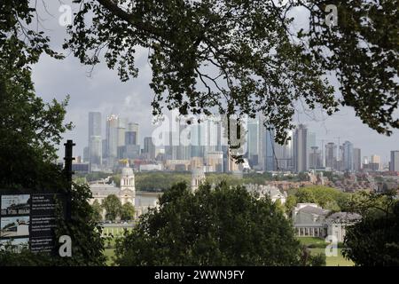 Die wunderschöne Aussicht auf das Royal Naval College, Canary Wharf und viele moderne Wolkenkratzer von einem Hügel in Greenwich Park, London, Großbritannien. Stockfoto