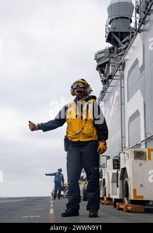 PACIFIC OCEAN (16. Februar 2024) Aviation Boatswain’s Mate (Handling) 1st Class Kenny NGO aus Upland, Kalifornien, die dem vorwärtsgerichteten amphibischen Angriffsträger USS America (LHA 6) zugeteilt wurde, signalisiert ein freies Flugdeck während der Durchführung von Flugoperationen im Pazifischen Ozean, 16. Februar. America, Leitschiff der America Amphibious Ready Group, ist im Einsatzgebiet der 7. US-Flotte im Einsatz. Die 7. US-Flotte ist die größte nach vorne gerichtete nummerierte Flotte der US Navy und interagiert routinemäßig mit Verbündeten und Partnern, um eine freie und offene Region im Indo-Pazifik zu erhalten. Na Stockfoto