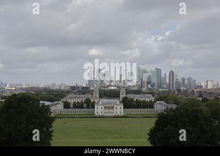 Die wunderschöne Aussicht auf das Royal Naval College, Canary Wharf und viele moderne Wolkenkratzer von einem Hügel in Greenwich Park, London, Großbritannien. Stockfoto