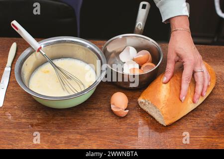 In einer Schüssel gibt es eine Mischung für ein Omelett und auf den Schalen für Eier und Brot. Bereiten Sie das Frühstück zu. Stockfoto