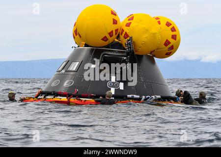 U.S. Navy Divers, die der Detective Ordnance Disposal Mobile Unit 1 zugewiesen sind, befestigen ein Rettungsfloß der NASA „Front Porch“ an einem Crew Module Test article (CMTA) während des Laufwerktests 11, 25. Februar 2024. In Vorbereitung auf die bemannte Mission Artemis II der NASA, die vier Astronauten nach Orion jenseits des Mondes entsenden wird, werden die NASA und das Verteidigungsministerium eine Reihe von Tests durchführen, um die Prozesse, Verfahren und Hardware zu demonstrieren und zu bewerten, die bei der Bergung von bemannten Mondmissionen eingesetzt werden. Amphibische Transportdocks wie die USS San Diego verfügen über einzigartige Funktionen, die sie zu einem idealen Partner machen Stockfoto