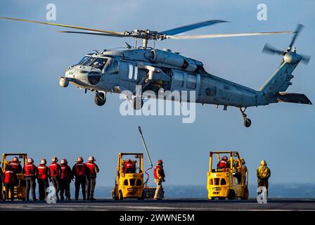 240221-N-TY639-1186 ATLANTIC OCEAN, Va. (21. Februar 2024) ein MH-60S Sea Hawk Helikopter, der den 'Dragonslayers' der Helicopter Sea Combat Squadron (HSC) 11 zugeordnet ist, platziert während einer vertikalen Auffüllung am 21. Februar 2024 Fracht auf dem Flugdeck des Flugzeugträgers USS Harry S. Truman (CVN 75) der Nimitz-Klasse. Truman ist das Flaggschiff der Harry S. Truman Carrier Strike Group und wird derzeit als Teil der Basisphase auf dem Weg gebracht. ( Stockfoto