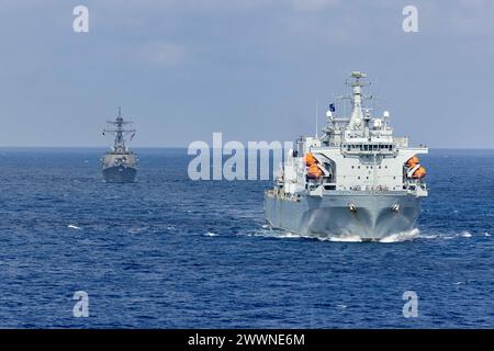 Arleigh Burke-Klasse der US-Navy Arleigh Burke (DDG 51), links und Royal Fleet Hilfsschiff RFA Argus (A 135), rechts, Transit in Formation im Mittelmeer, 25. Februar 2024. Die Bataan Amphibious Ready-Gruppe wurde zum NATO-Kommando im östlichen Mittelmeer überstellt, um eine Reihe kurzfristiger Wachsamkeitsaktivitäten mit Mitgliedern der Ständigen NATO-Maritime-Gruppe 2 des Alliierten Seekommandos und der türkischen Marine durchzuführen. Marine Corps Stockfoto