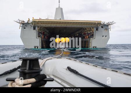 Ein aufblasbares Boot mit starrem Rumpf schleppt während des laufenden Recovery Test 11, 25. Februar 2024 einen Crew Module Test article (CMTA) vom Brunnendeck des Amphibien-Transportdocks der San Antonio-Klasse USS San Diego (LPD 22). In Vorbereitung auf die bemannte Mission Artemis II der NASA, die vier Astronauten nach Orion jenseits des Mondes entsenden wird, werden die NASA und das Verteidigungsministerium eine Reihe von Tests durchführen, um die Prozesse, Verfahren und Hardware zu demonstrieren und zu bewerten, die bei der Bergung von bemannten Mondmissionen eingesetzt werden. Amphibische Transportdocks, wie die USS San Diego, haben einzigartige Fähigkeiten, die sie zu einem i machen Stockfoto