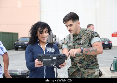 Shawn Gleason, Techniker für die Entsorgung von Sprengkörpern, Marine Wing Support Squadron 174, Marine Aircraft Group 24, 1st Marine Aircraft Wing, leitet NFL Cheerleaderin Geena Rojas während der Pro Blitz Tour 2024 auf der Marine Corps Base Hawaii, 2. Februar 2024. Der Besuch bot Service-Mitgliedern und ihren Familien die Möglichkeit, pensionierte und aktuelle NFL Cheerleader und Football Hall of Fame Honorees zu treffen. Marine Corps Stockfoto