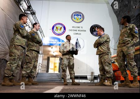 Fünf Mitglieder des Militärdienstes hören sich ein Briefing auf der Cheyenne Mountain Space Force Station, Colorado, 15. Februar 2024 an. Dieser formelle Eingang in die Cheyenne Mountain-Anlage zeigt die Insignien von vier Pächtern der Anlage: North American Aerospace Defense Command, U.S. Northern Command, Air Force Space Command und U.S. Strategic Command. Raumkraft Stockfoto