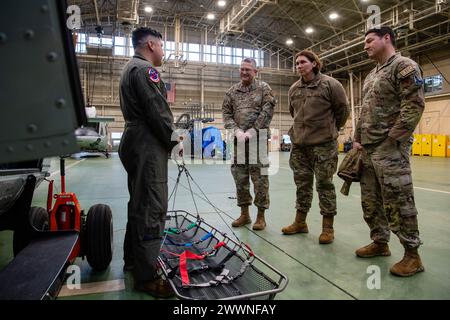 Von links nach rechts: U.S. Air Force Tech. Sgt. Jeovany Vasquez, Unteroffizier der 459th Airlift Squadron, verantwortlich für Taktik, spricht mit Chaplain (Generalmajor) Randall Kitchens, dem Chef der Kaplane der USAF, und Chief Master Sgt. Sadie Chambers, leitender Berater für religiöse Angelegenheiten, über luftmedizinische Evakuierungsverfahren auf der Yokota Air Base, Japan, 23. Februar 2024. Die 459th AS unterhält UH-1N-Flugbesatzungen, um aeromedizinische Evakuierungen, Such- und Rettungseinsätze und vorrangige Lufttransporteinsätze in der gesamten Indo-Pazifik-Region durchzuführen. Luftwaffe Stockfoto