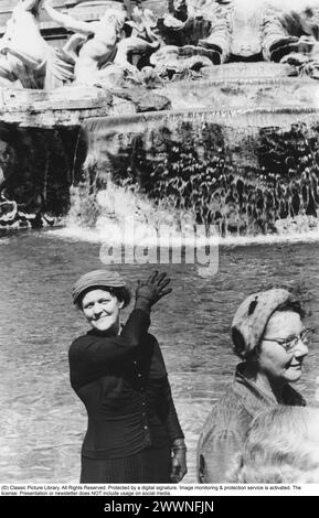 Trevi-Brunnen 1950er Jahre Ein Brunnen an der Piazza di Trevi im Zentrum von Rom. Anita Ekberg wurde berühmt für ihr Bad im Brunnen im Film La Dolce vita. Eine Frau wird gesehen, wie sie eine Münze in den Brunnen wirft, wie es sein sollte. Sie wirft mit der rechten Hand über ihre linke Schulter. Es gibt verschiedene Theorien über die Wirkung, Münzen in den Brunnen zu werfen und wie viele Münzen geworfen werden sollen. Nach der Ursprungslegende ist es jedoch garantiert, dass Sie nach Rom zurückkehren, wenn Sie eine Münze werfen. Conard Ref. 519 Stockfoto