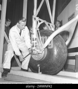 Großer Reifen in den 1940ern Ein junger Mechaniker an einem Reifen und Fahrwerk eines Douglas DC3 Flugzeugs. 1943. Kristoffersson Ref. F22-1 Stockfoto