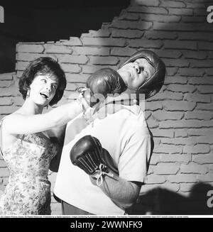 Schauspielerin Lill-Babs Svensson während der Dreharbeiten zum schwedischen Spielfilm Svenska Floyd, in dem Lill-Babs die Sängerin und Schönheit Lollo Fillipini und Carl-Gustaf Lindstedt als Boxer Flosse, alias Svenska Floyd aus Nockeby, spielt. Auf dem Bild sieht man, wie sie einen Aufwärtstrumpf auf seinem Kinn landet. 1961 Kristoffersson Ref. CS14-7 Stockfoto