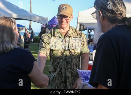 Force Master Chief Jason Dunn, der leitende Anführer des Kommandanten, Navy Installations Command, das weltweit 70 Marinebasis überwacht, spricht mit den Einwohnern von Hawaii über das langfristige Trinkwasser-Überwachungsprogramm der Navy während eines Nachtmarktvorfalls in Ewa Beach, Hawaii, am 14. Februar 2024. Die Navy veranstaltet einen monatlichen Informationsstand an verschiedenen Orten, um die Öffentlichkeit über das Programm zu informieren und die Trinkwasserergebnisse auf der Joint Base Pearl Harbor-Hickam Safe Waters Website zu lesen. Dunn ist einer von mehreren Marineführern, die nach Hawaii reisten, um die Navy Closing Task Forc zu unterstützen Stockfoto