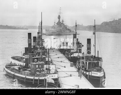 Stockholmer Hafen 1937. Blick auf Stockholmer Hafen und Hafeneingang. An Slussen und dem Bootssteg gibt es Schlepper kleinerer Art mit Namen wie Emy, Venus, Hugin, Strömåkaren. Im Hintergrund steht ein Kriegsschiff der schwedischen Küstenflotte vor Anker. Rechts Stadsgården. Stockfoto