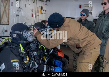 Der Senior Chief der US Coast Guard Petty Jeff Esser, ein Taucher, überprüft die Maske von Petty Officer 2nd Class Chuck Fox, einem Taucher, auf dem Coast Guard Cutter Polar Star (WAGB 10), bevor er den südlichsten Tauchgang der Geschichte in der Bay of Whales, Antarktis, am 3. Februar 2024 absolviert. Jedes Jahr arbeitet ein gemeinsames Team an der erfolgreichen Operation Deep Freeze zusammen. Aktive Mitglieder der US-Luftwaffe, der US-Armee, der Küstenwache und der Navy arbeiten zusammen, um eine starke Joint Task Force-Unterstützungsstreitkräfte der Antarktis zu bilden, die die Tradition des US-Militärs fortsetzt Stockfoto