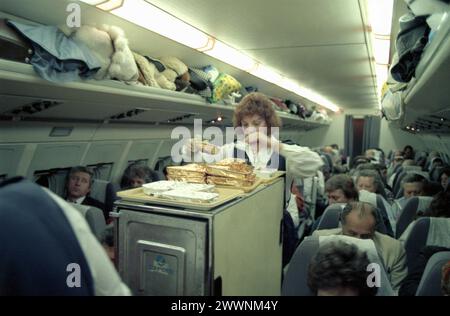 Januar 1990. Flugbegleiter serviert Mittagessen in einem TAROM-Flugzeug während eines internationalen Fluges von New York nach Bukarest, Rumänien. Stockfoto