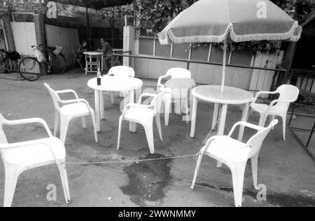 Buzau County, Rumänien, 1990. Wenige Monate nach dem Niedergang des Kommunismus tauchen überall kleine private Cafés und Bars auf. In diesem Bild die Terrasse eines Unternehmens in einem Dorf, mit Stühlen, die mit Seilen gebunden sind, um Diebstahl zu verhindern. Stockfoto