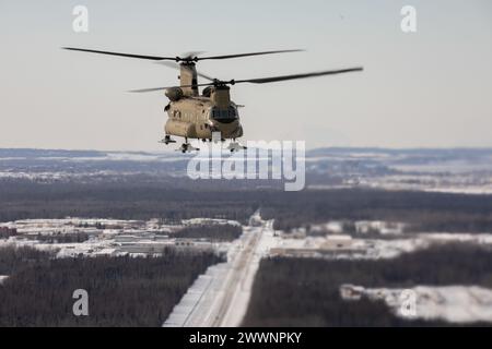 Ein Hubschrauber der Alaska Army National Guard CH-47F Chinook fliegt über der Joint Base Elmendorf-Richardson, Alaska, während er Schleudertraining durchführt, 28. Februar 2024. Soldaten der US-Armee des Alaska Army National Guard Aviation Battalion führten das mit Schleudern beladene Training durch, um ihre Einsatzfähigkeit in Alaskas rauer Umgebung zu verbessern. (Alaska Nationalgarde Stockfoto