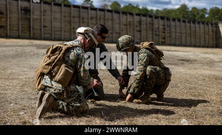 U.S. Marine Corps Sgt. Alex Fiedler, Zentrum, ein Sprengstoffentsorgungstechniker im 8. Ingenieur-Support-Bataillon, Combat Logistics Regiment 27, 2. Marine Logistics Group, zeigt CPL. Grant Pederson, links, eine Feldartillerie-Feuerkontrolle mit 10. Marine-Regiment, 2. Marine-Division, und Lance CPL. Isaac Arellano, ein Metallarbeiter im 2. Wartungsbataillon, 2. Combat Readiness Regiment, 2. MLG, wie man sich während eines Abbruchs in Camp Lejeune, North Carolina, am 13. Februar 2024 auf der Erde erdet. Das Training setzte die 2. MLG und 2. Marine Division Marines der EO aus Stockfoto