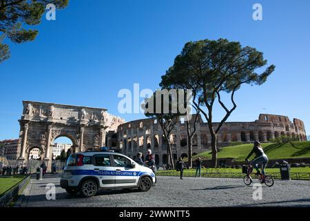 Rom, Italien. März 2024. Polizeibeamte stehen am 25. März 2024 in der Nähe des Konstantinsbogens und des Kolosseums in Rom, Italien. Das italienische Innenministerium sagte am Samstag, dass es angeordnet habe, das Sicherheitsniveau an "sensiblen" Orten in Rom und anderen Städten, einschließlich Flughäfen, Bahnhöfen sowie wichtigen kulturellen und religiösen Stätten, zu erhöhen. Quelle: Li Jing/Xinhua/Alamy Live News Stockfoto