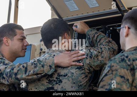 Staff-Sgt. Henry Garcia, Zentrum, Netzwerkchef des Bataillons Landing Team 1/5, 15. Marine Expeditionary Unit, und ein New Yorker, installiert und konfiguriert Router in einem Joint Light Tactical Vehicle an Bord des Amphibientransportdocks USS Somerset (LPD 25), während er am 16. Februar 2024 in der Philippinischen See unterwegs ist. Somerset und einschiffte Teile der 15. Marine Expeditionary Unit führen Routineoperationen im Einsatzgebiet der 7. US-Flotte durch. Die 7th Fleet ist die größte nach vorne ausgerichtete nummerierte Flotte der US Navy und interagiert routinemäßig mit allen Stockfoto