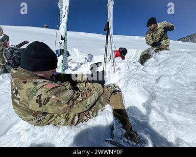 SPC. Samuel Bonney (links), Spezialist für Massenkommunikation beim 27. Public Affairs Detachment aus Cape Girardeau, Missouri, Films Lt. Colonel Gregory Eldridge (rechts), stellvertretender Feuerwehrkoordinator der 10. Mountain Division, während der Schneegruben wurde am 17. Februar 2024 ein Lawinentraining durch die National Ski Patrol in Chalk Creek auf einer Höhe von 11.800 Metern in der Nähe von Leadville, Colorado, durchgeführt. Dieses intensive Programm hat sie mit grundlegenden Fähigkeiten ausgestattet, darunter sicheres Lawinenreagieren, fachkundige Bedienung des Transceivers, effektive Sondierungsmethoden, effiziente Schaufeltechniken und Stockfoto