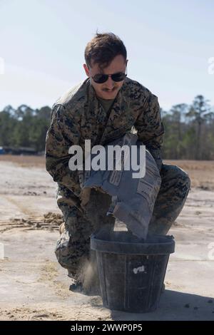 Andrew Wisniewski, Kampfingenieur des 8. Engineer Support Battalion, 2. Marine Logistics Group, gießt Zementbinder während der Übung Winter Pioneer 24, Marine Corps Outlying Field Oak Grove, North Carolina, 15. Februar 2024. Die Ingenieure des U.S. Marine Corps und die US Navy Construction Force nutzten das Marine Corps Outlying Field Oak Grove für Marines und Seeleute, um den Aufbau und die Aufrechterhaltung fortgeschrittener Marinestützpunkte zu Proben, die zur Sensibilisierung der maritimen Gebiete beitragen. Marine Corps Stockfoto