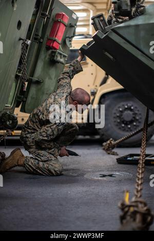 Lucas Hough, ein leichter gepanzerter Wagen 25 Schütze der Light gepanzerten Reconnaissance Company, Bataillon Landing Team 1/5, 15. Marine Expeditionary Unit, und ein Eingeborener aus Iowa, inspiziert eine LAV-25 während der routinemäßigen Fahrzeugwartung an Bord des amphibischen Transportdocks USS Somerset (LPD 25) im Pazifischen Ozean, 2. Februar 2024. Somerset führt derzeit Routineoperationen im US-Gebiet der 3rd Fleet mit Elementen der 15th MEU durch. Marine Corps Stockfoto