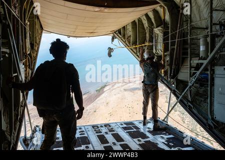 Ein Pararescueman der US Air Force, der 82nd Expeditionary Rescue Squadron, links, zugeteilt wird, beobachtet als Loadmaster des U.S. Marine Corps, der Marine Medium Tiltrotor Squadron 261, oder VMM-261 (REIN), zugewiesen ist, holt am 27. Februar 2024 einen Fallschirm über Ostafrika. Gemeinsame Dienstschulungen bieten die Möglichkeit, wichtige Beziehungen zu Schwesterdiensten zu pflegen und gleichzeitig eine stärkere gemeinsame Kraft aufzubauen. Luftwaffe Stockfoto