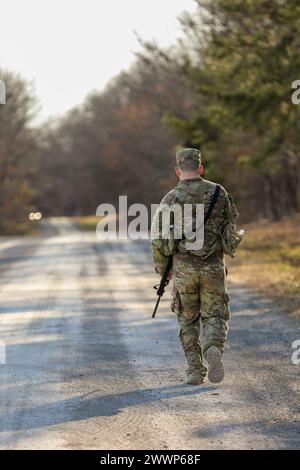 Noah Green von der 194th Engineer Brigade (EB) unterstützt seinen Kollegen beim Tennessee State Best Warrior Competition in Tullahoma am 25. Februar 2024. Green hatte den ruckmarsch bereits beendet und wollte sicherstellen, dass die Vertretung der 194. EB einen starken Abschluss für den Wettbewerb hatte. Armee-Nationalgarde Stockfoto