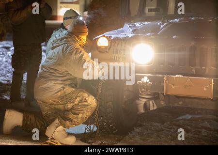 US-Soldaten, die dem 2nd Infantry Brigade Combat Team (Airborne), 11th Airborne Division „Arctic Angels“ zugewiesen sind, installieren Schneeketten auf einem Militärfahrzeug während des Cold Weather Indoktrination Course II auf Fort Wainwright, Alaska, 4. Februar 2024. Für Soldaten ist es wichtig, zu verstehen, wie Fahrzeuge bei extremer Kälte betrieben werden. Schneeketten verbessern die Traktion auf Eis und Schnee. Die Arktis ist ein dynamisches Umfeld, in dem Führer und Soldaten vorbereitet, anpassungsfähig und in der Lage sind, in einer rauen Umgebung zu arbeiten, die sich schnell und plötzlich ändert. Armee Stockfoto