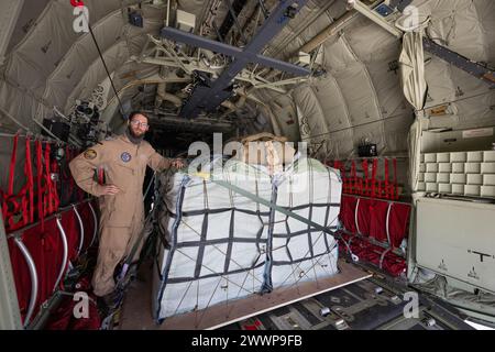 Amman, Jordanien. März 2024. Ein Laderaummeister prüft die Befestigung der Zurrgurte auf Paletten von Hilfsgütern an Bord eines C-130 Hercules Transportflugzeugs der Deutschen Luftwaffe. Die Bundeswehr beteiligt sich mit anderen Nationen an Hilfsflügen, bei denen die Hilfsgüter aus Transportflugzeugen fallen gelassen werden. Quelle: Boris Roessler/dpa/Alamy Live News Stockfoto