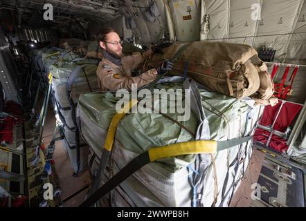 Amman, Jordanien. März 2024. Ein Laderaummeister prüft die Befestigung der Zurrgurte auf Paletten von Hilfsgütern an Bord eines C-130 Hercules Transportflugzeugs der Deutschen Luftwaffe. Die Bundeswehr beteiligt sich mit anderen Nationen an Hilfsflügen, bei denen die Hilfsgüter aus Transportflugzeugen fallen gelassen werden. Quelle: Boris Roessler/dpa/Alamy Live News Stockfoto