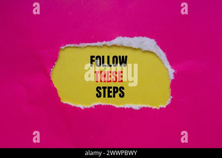 Befolgen Sie die folgenden Schritte, die auf rosafarbenem Papier mit gelbem Hintergrund geschrieben sind. Konzeptsymbol. Kopierbereich. Stockfoto
