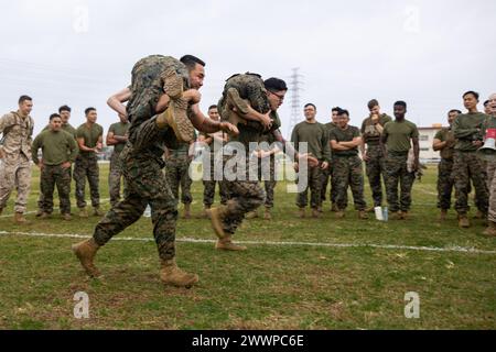 Die United States Marines Marine Wing Support Squadron (MWSS) 172 und Marine Aviation Logistics Squadron (MALS) 36 führen Buddy Carry während eines Feldtreffens in Camp Foster, Okinawa, Japan, am 9. Februar 2024 durch. Die Marines mit den Hauptquartiern der Marine Wing Squadron 1, MWSS-172 und MALS-36 hielten das Feldtreffen ab, um ein Gefühl der Kameradschaft, des gesunden Wettbewerbs und des esprit de Corps zwischen den drei Geschwadern zu fördern. Marine Corps Stockfoto