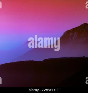 Spektakuläre Silhouetten der Bergketten in violetten und schwarzen Tönen. Stockfoto