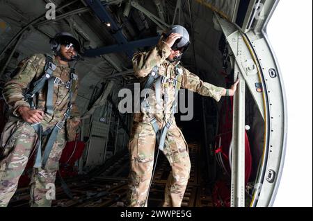 Von links aus sehen der Senior Airman Milo Carter, Ausbilder der 36th Airlift Squadron und Losaia Lavata’i, 36th ALS Loadmaster, die Truppentür eines USAF C-130J Super Hercules, der dem 36th auf der Yokota Air Base, Japan, am 22. Februar 2024 zugeteilt wurde. Die Ladungsträger simulierten Personalabfälle und füllten eine Checkliste während des Fluges aus, um sicherzustellen, dass simulierte Fallschirmjäger ordnungsgemäß aus dem Flugzeug befreit wurden. Luftwaffe Stockfoto