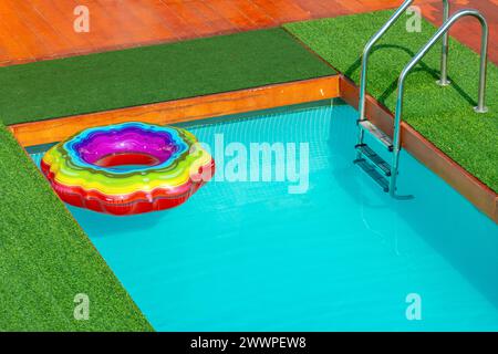 Farbenfroher aufblasbarer Ring auf der Oberfläche des Schwimmbades Stockfoto