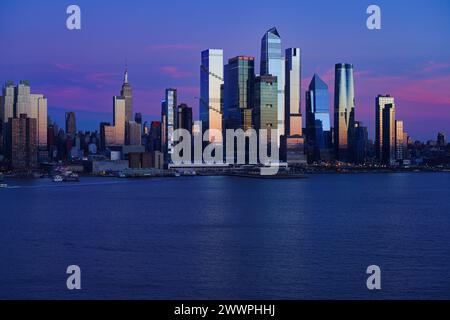 WEEHAWKEN, NJ -18. Februar 2024 - Blick bei Sonnenuntergang auf die Skyline des Ufers in Manhattan, New York, von der anderen Seite des Hudson River in New Jersey. Stockfoto