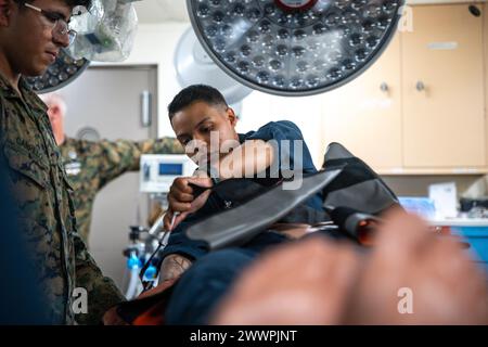 Die US Navy Hospital Corpsman 2nd Class Diana Elston, eine aus Alabama stammende, dem Amphibientransportdock USS Somerset (LPD 25) zugeteilt wurde, bewertet einen simulierten Unfall während einer medizinischen Ausbildung an Bord von Somerset, während sie am 14. Februar 2024 in der Philippinischen See unterwegs ist. Somerset und einschiffte Teile der 15. Marine Expeditionary Unit führen Routineoperationen im Einsatzgebiet der 7. US-Flotte durch. Die 7th Fleet ist die größte nach vorne gerichtete nummerierte Flotte der US Navy und interagiert routinemäßig mit Verbündeten und Partnern, um eine freie und offene Region im Indo-Pazifik zu erhalten. Marine Stockfoto