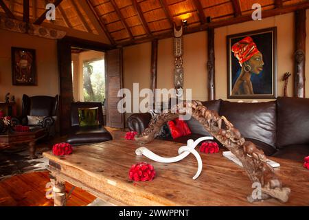 Das Innere der Haupthütte mit dekorativen afrikanischen Gegenständen im Amakhala Game Reserve, Südafrika, wo die Gäste sich vor der Fahrt treffen und essen. Stockfoto