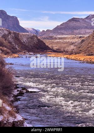 Fisherman stromaufwärts im schnell fließenden Shoshone River hat im Februar Winter einen Blick auf die Berge, die in den Yellowstone-Nationalpark von Cody, Wyoming, führen. Stockfoto