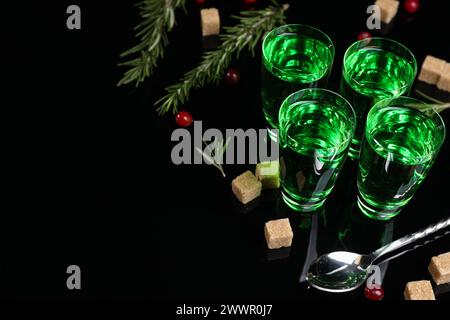 Absinth in Shot Gläsern, Preiselbeeren, Rosmarin und brauner Zucker auf Spiegeltisch, Platz für Text. Alkoholisches Getränk Stockfoto