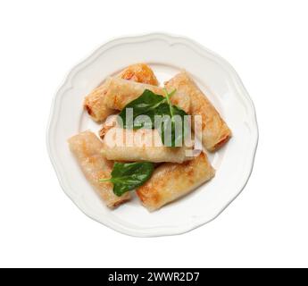 Leckere gebratene Frühlingsbrötchen und Spinat isoliert auf weiß, Blick von oben Stockfoto