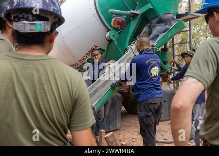 Royal Thai Marines mit der Royal Thai Marine Corps Construction Company of Combat Engineers gießen Beton für einen Gehsteig auf der Ban Prakaet School Baustelle in Chanthaburi, Thailand, 27. Februar 2024. Marines of Marine Wing Support Squadron 171 haben ihre technische Expertise für multilaterale humanitäre Bemühungen während der Cobra Gold 24 bereitgestellt. Cobra Gold ist die größte gemeinsame Übung auf dem asiatischen Festland und ein konkretes Beispiel für die starke Allianz und strategische Beziehung zwischen Thailand und den Vereinigten Staaten. Dies ist die 43. Wiederholung der multilateralen Übung vom Februar. Stockfoto