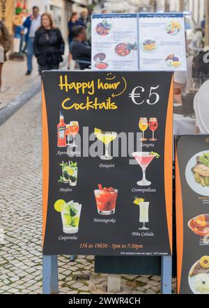 Schild vor einer Bar in Lissabon, Portugal, für die Happy Hour Cocktails geworben wird Stockfoto